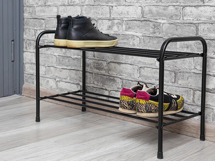 Black metal shoe storage bench with two pairs of shows. 